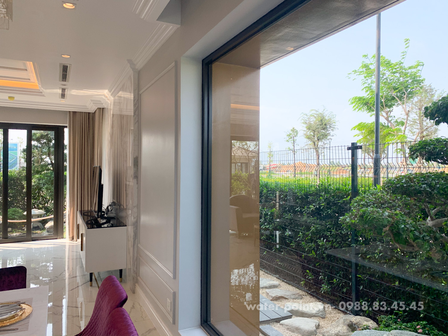 Từ phòng khách, chủ nhân có thể phóng mắt nhìn ra sân nhà và hồ cá KOI thông qua các cửa sổ tấm lớn trong suốt